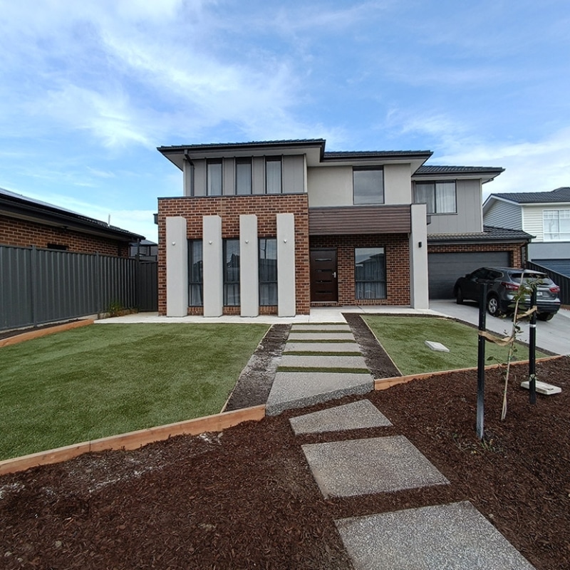 A well-maintained house featuring a driveway and green grass, reflecting the elegant landscaping in Epping